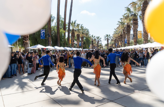Dance performance of students in front of a crowd of people during Homecoming