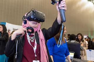 Person in VR goggles reaches out, interacting with equipment