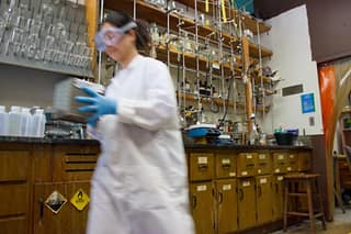 Person in motion walks through a lab with lab gear on